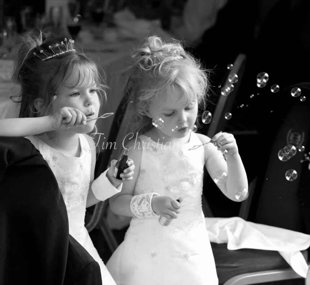 Leeds, West Yorkshire Wedding Photographer Captured little bridesmaids blowing bubbles together during the wedding breakfast