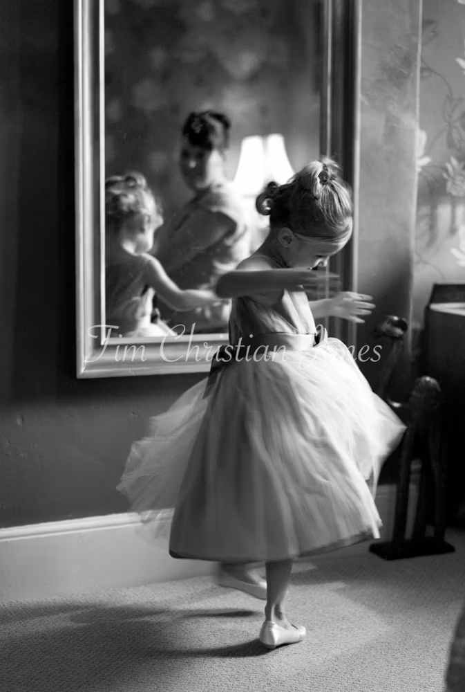 Bride's daughter twirling by the mirror showing off her dress