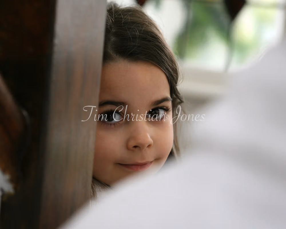Bride's young daughter photographed during the wedding preparation session, I am a welcome presence as a Leeds-based wedding photographer