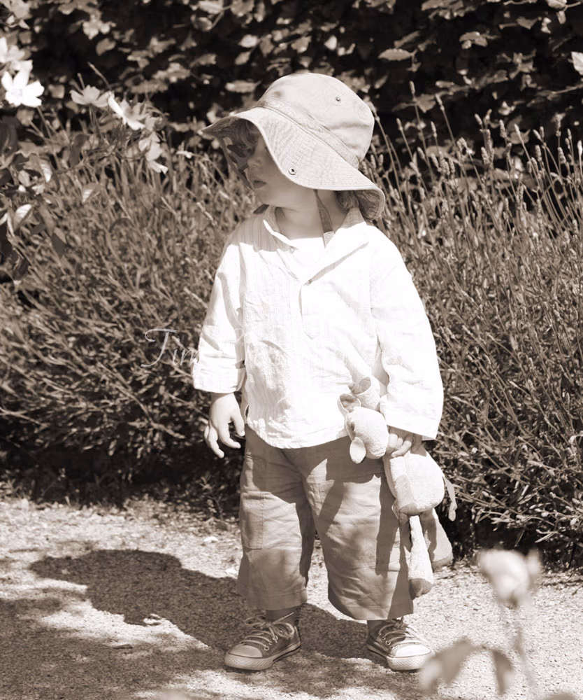 Bride's son in sepia tone looking lost holding his toy photographed by Tim Christian Jones