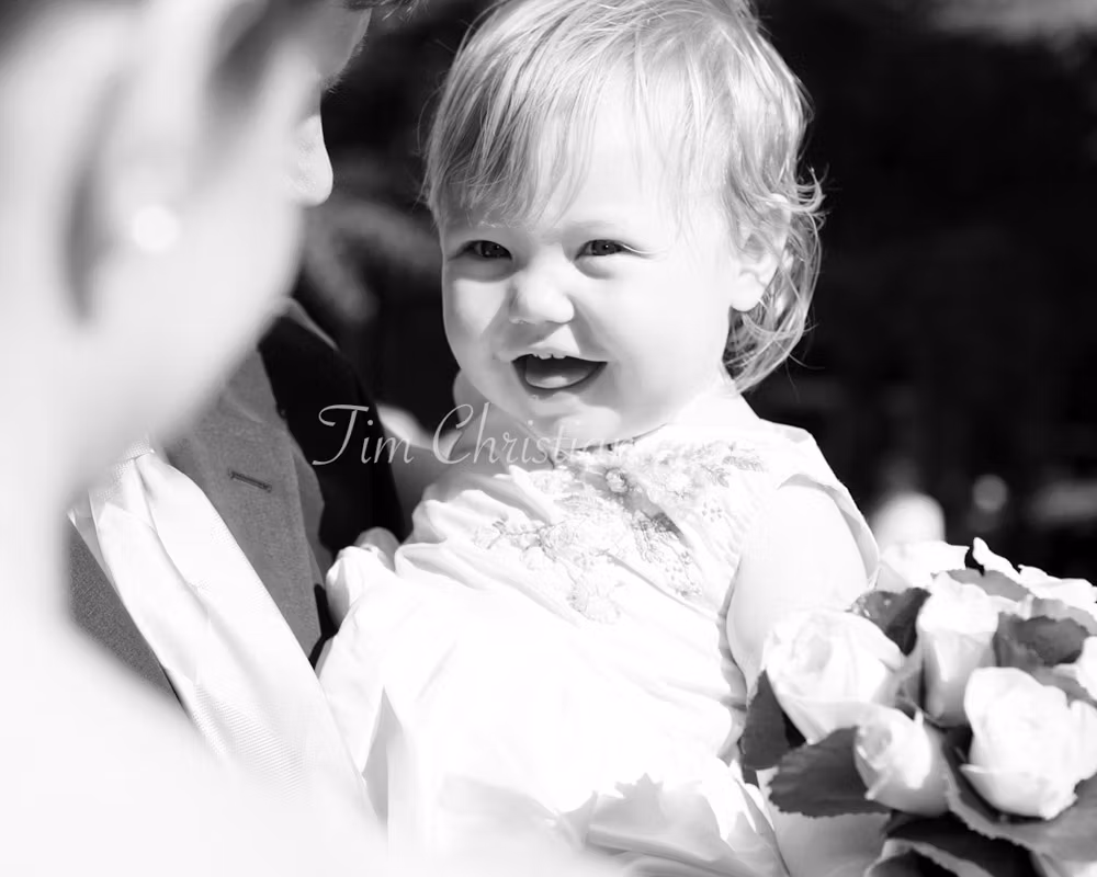 Bride's daughter smiling at her mom from a 2004 wedding photographed by a Leeds-based wedding photographer Tim Christian Jones