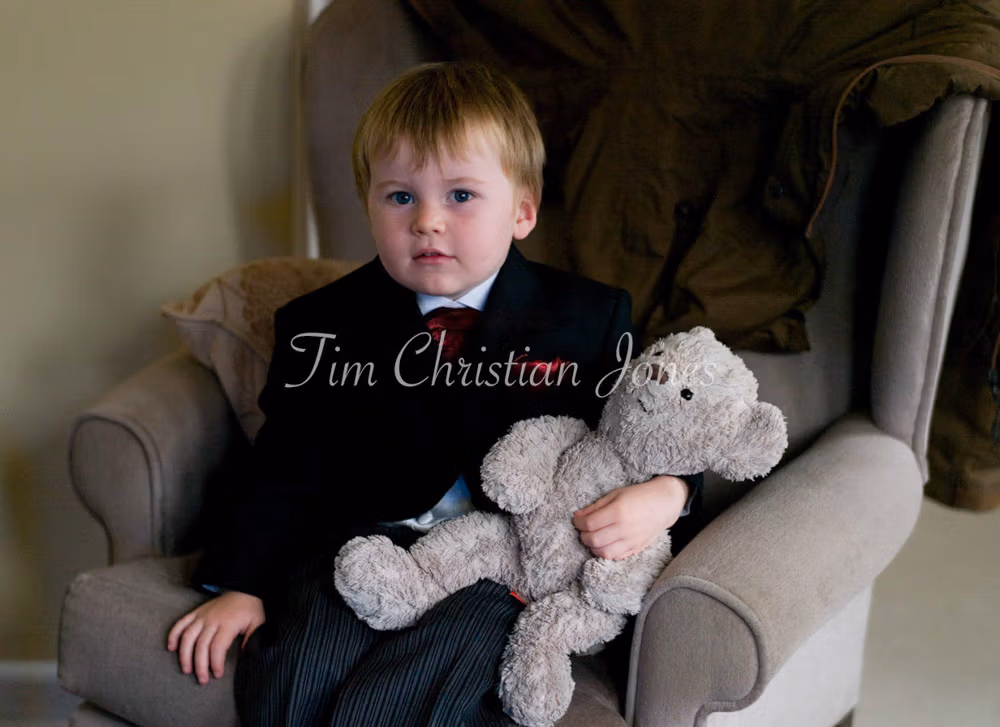 Pageboy sat with his teddy bear at a Yorkshire winter wedding