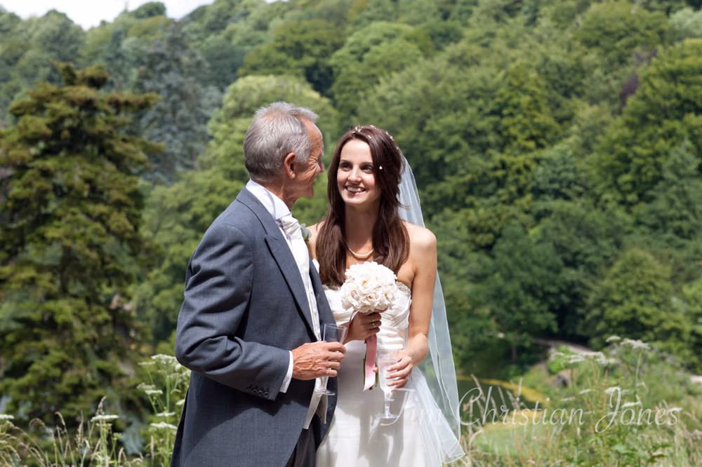 Bride and her father pause for a casual photo outdoors before the reception