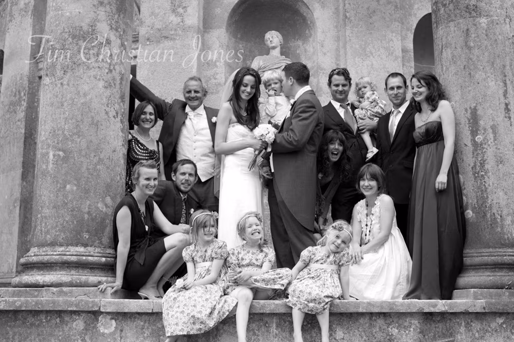 Black and white photo of a relaxed family group by the columns of the Temple of Apollo