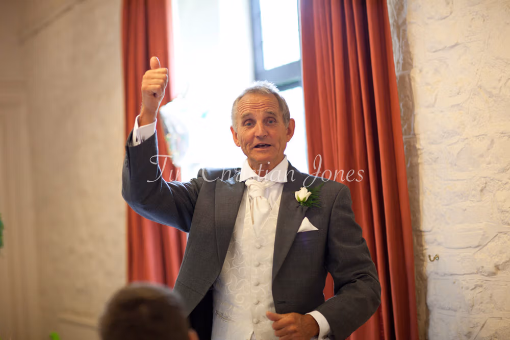 Father of the bride stands to begin his speech at the top table