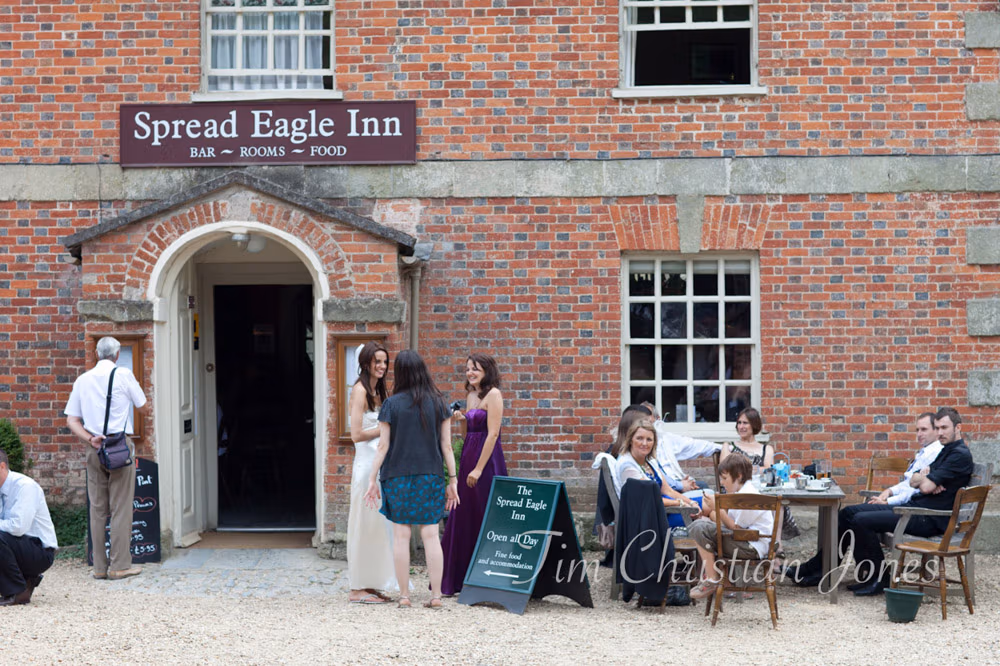 Guests chatting with the bride outside The Spread Eagle