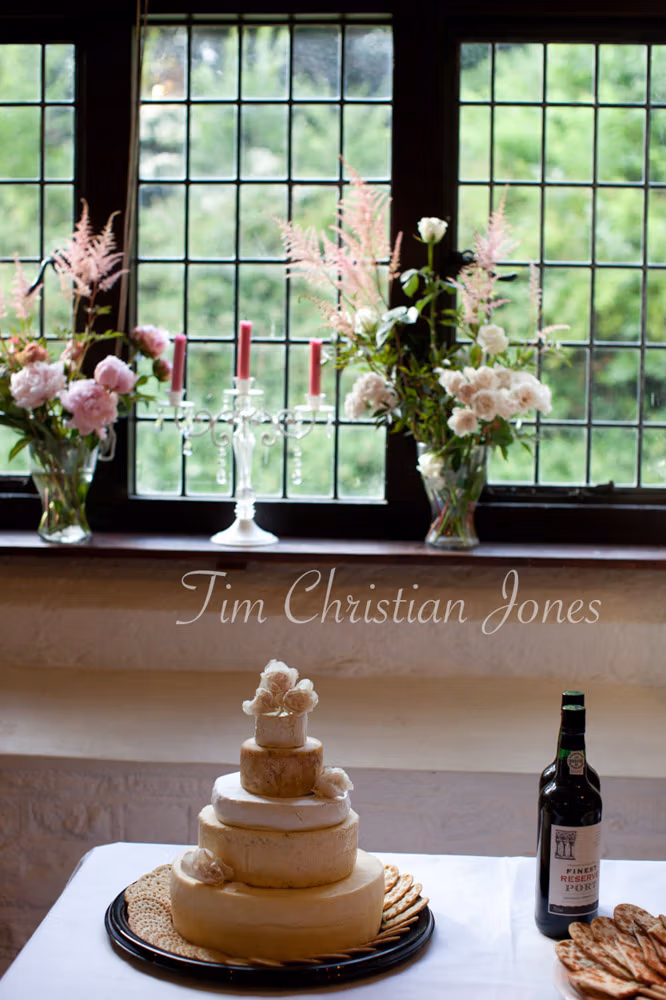 Tiered wedding cheese cake beside a beautiful old leaded window