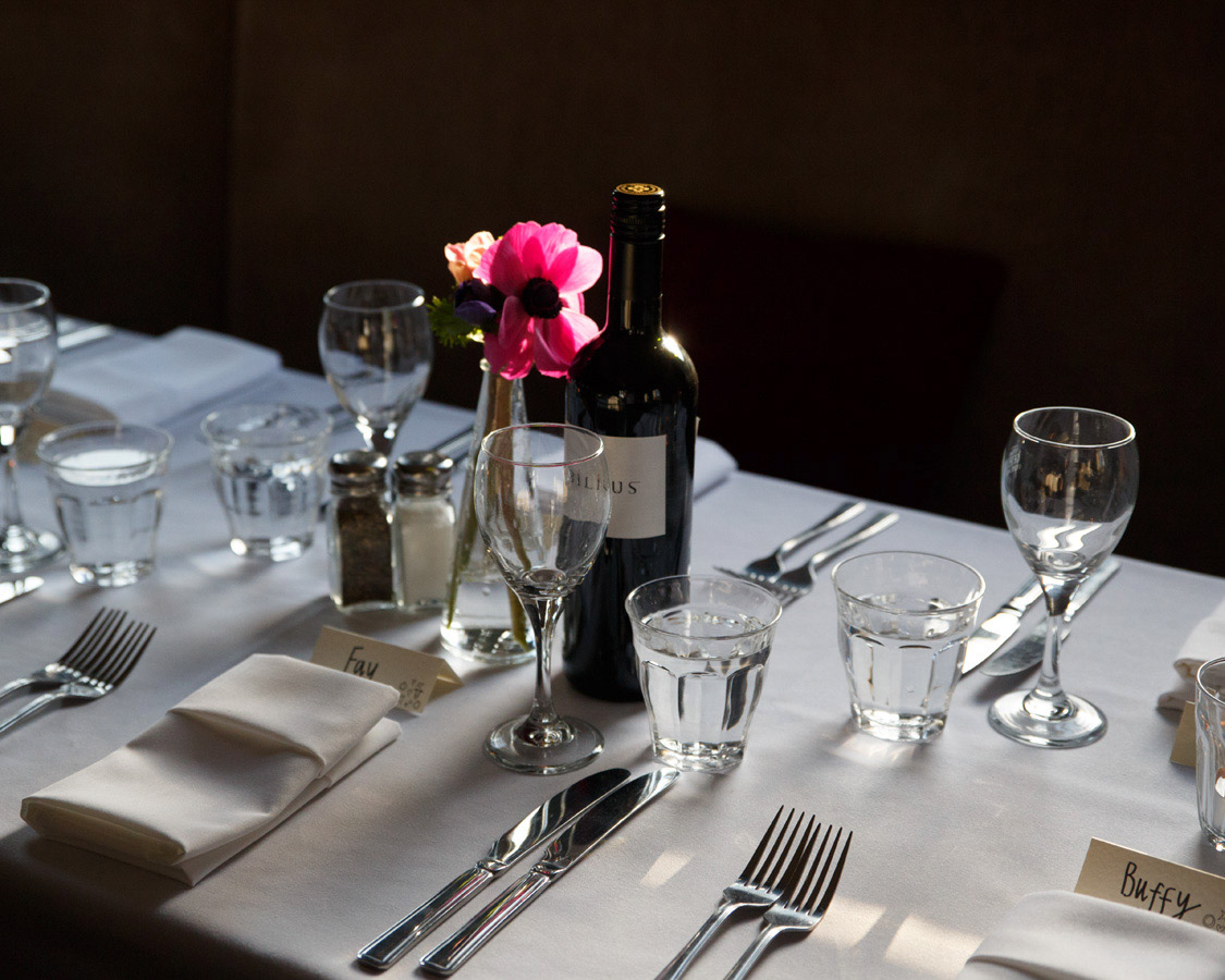 Rustic wedding breakfast table setting in a low light upstairs pub setting, captured naturally by a Leeds wedding photographer